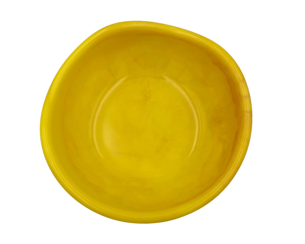 A small, organic-shaped yellow resin dish or shallow bowl, isolated on a solid white background.