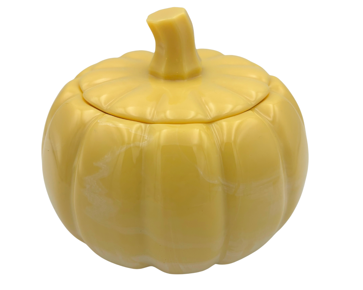 A yellow pumpkin-shaped resin lidded container with a ribbed texture and a short stem, shown on a plain white background.
