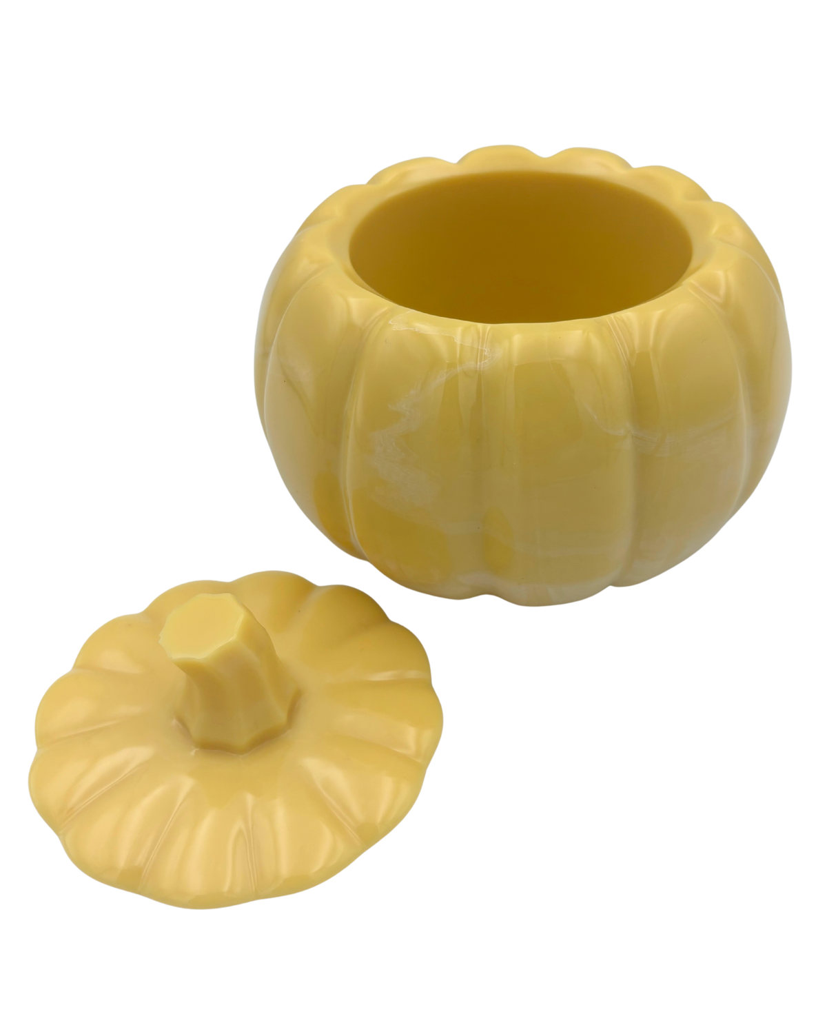 A yellow pumpkin-shaped resin lidded container with a ribbed texture and a short stem, shown on a plain white background.